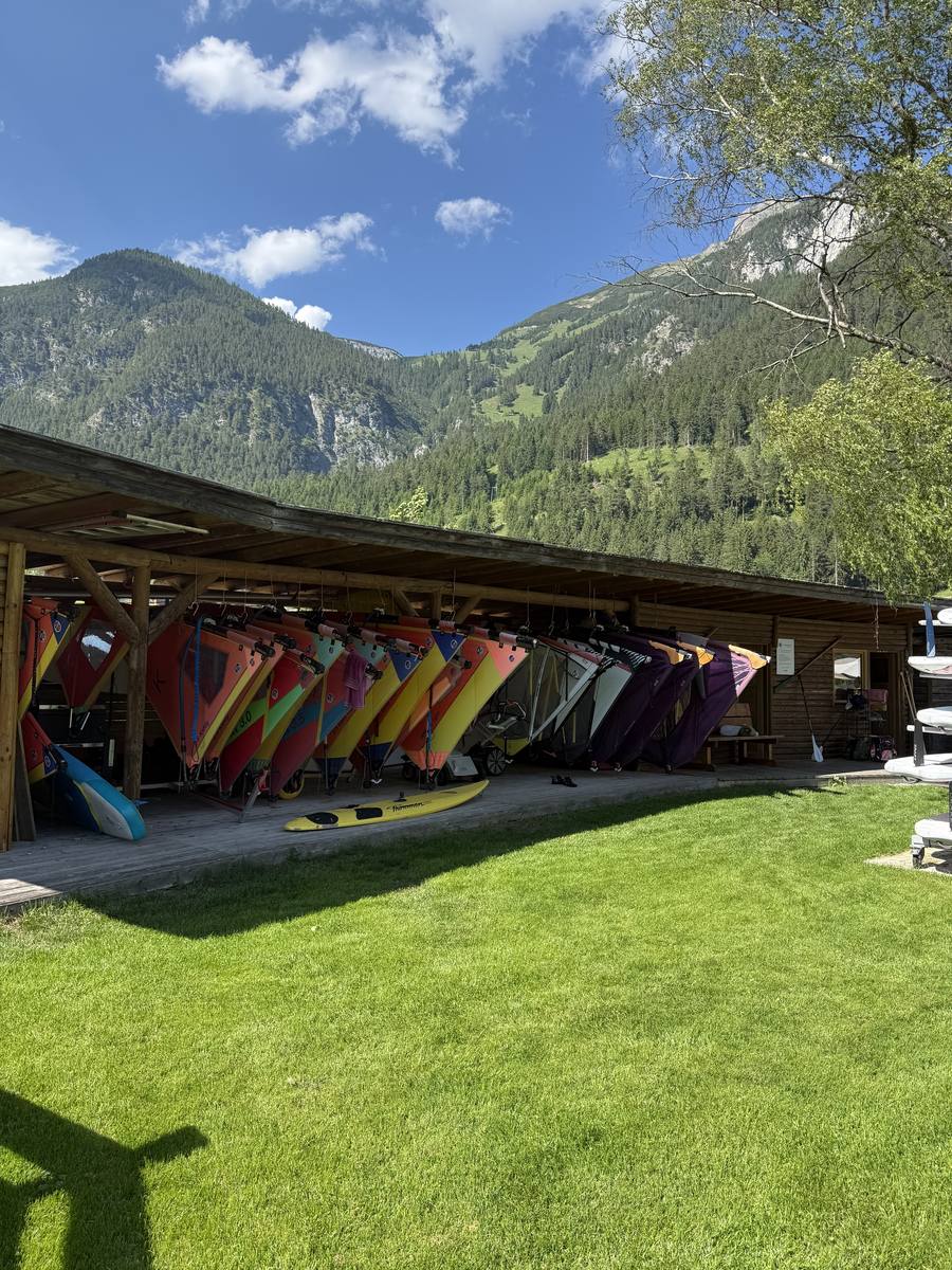 Reihe aufgeriggter Windsurfsegel in allen Größen