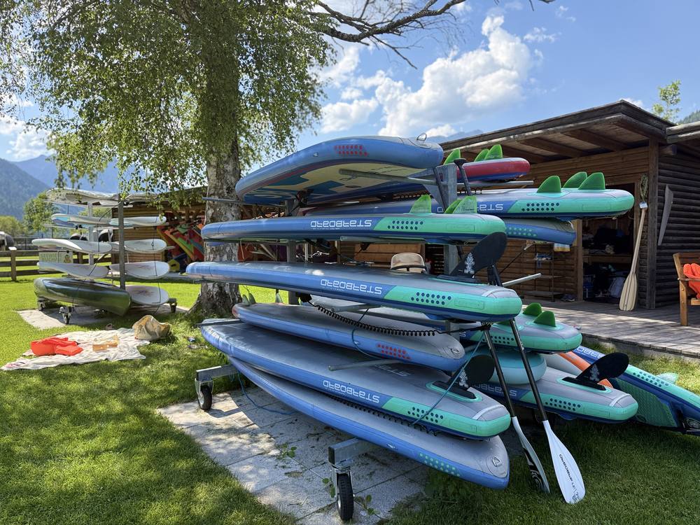 Gestapelte Starboard-SUP-Boards mit Paddeln vor der Hütte